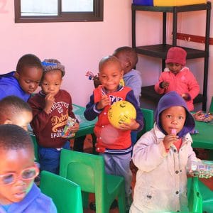 Children sitting on green chairs