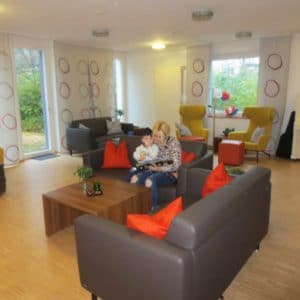 Living room with sofas, armchairs and curtains